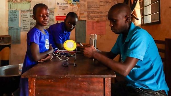 teacher teaching students in Africa with donated solar light