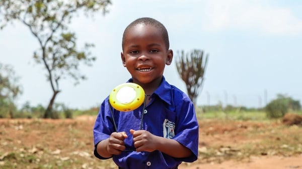 African student holding donated solar light