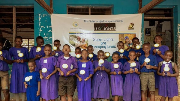 African students holding up donated solar lights